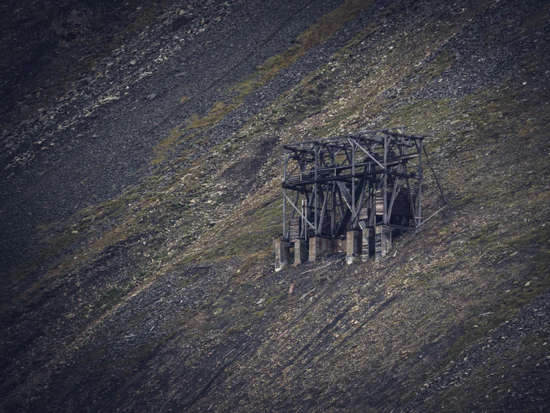 Steep mine terrain and a fixed structure illustrating monitoring positions occlusion and stable-reference needs