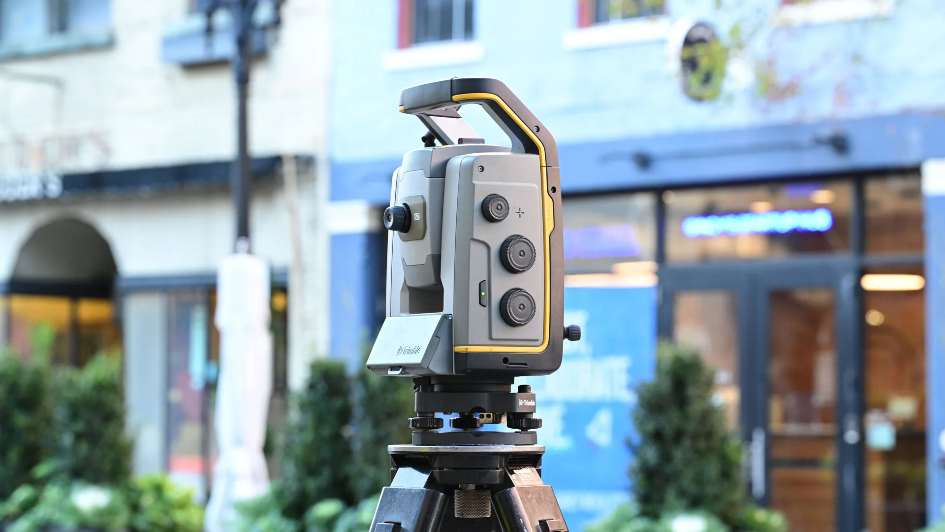 Survey instrument beside buildings illustrating the independent field measurements needed to check a drone survey