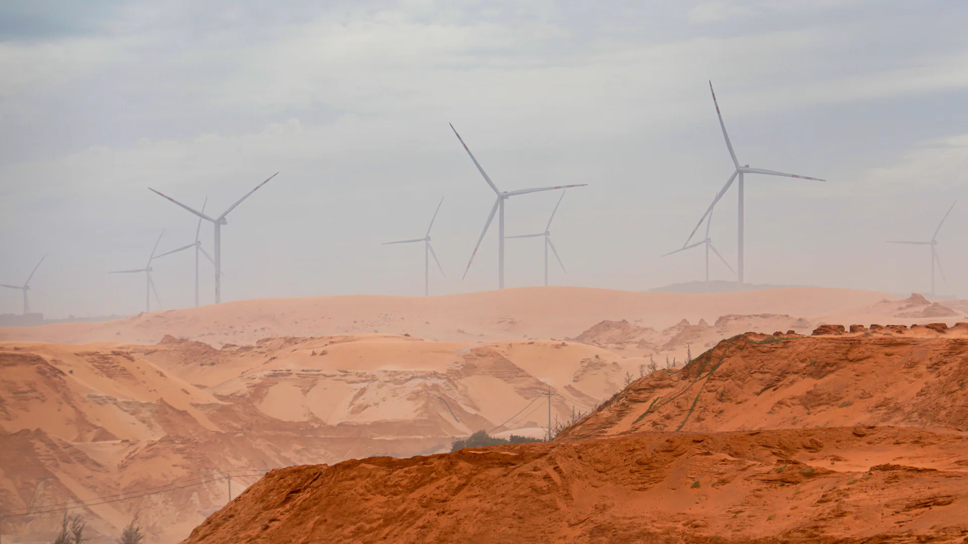 Wind turbines across open terrain where drone inspection coverage must account for turbine identity, wind and safe stand-off